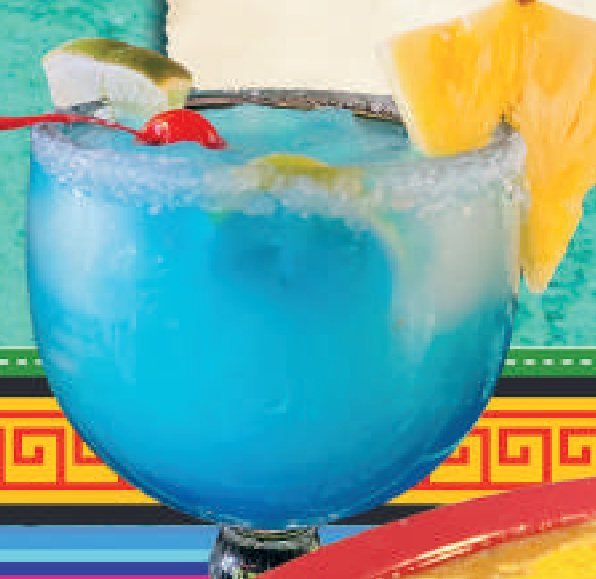 A frozen blue margarita in a salt-rimmed glass with lime and pineapple